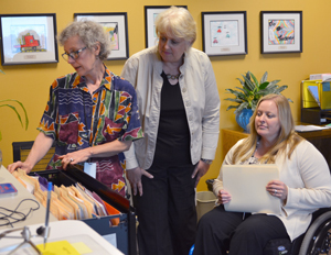 Celine Carpenter and Heidi Bryand consult with Pam Newsome