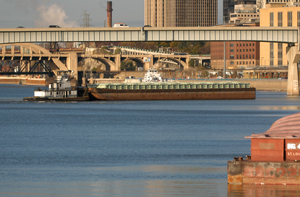 Photo of tugboat pushing a barge down the Mississippi River.