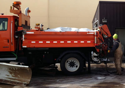 Snowplow being loaded with brine