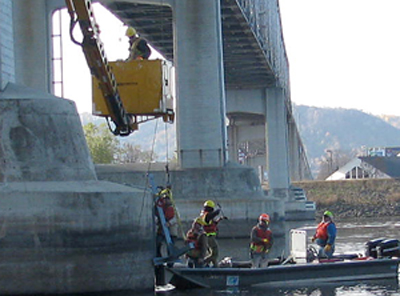 Photo of bridge workers installing an active sonar system on a bridge.