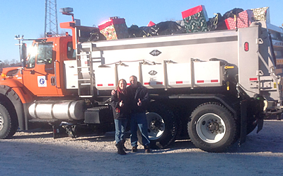 Photo of Mindy Heinkel and Cliff Gergen in front a truck full of toys.