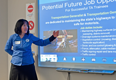 Photo of Christine Fisher presenting in front of a smart board.