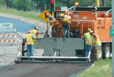 Photo of MnDOT working with a truck mounted paver.