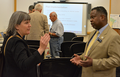 Photo of John Tompkins talking with Cathy Velasquez.