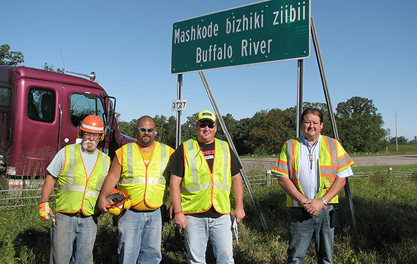 Photo of District 4 sign crew putting up dual language sign.