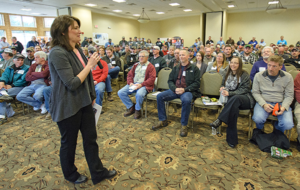 Woman stands in front of dozens of staff 