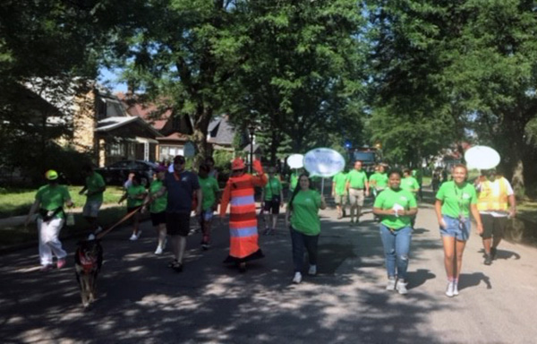 MnDOT employees in green t-shirts walk in the parade through the Rondo neighborhood