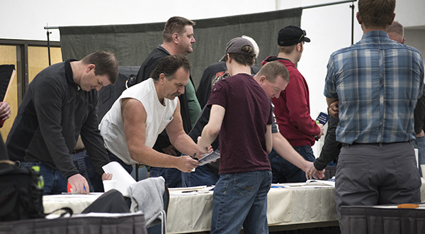 Picture of people lined up and signing in at a table.