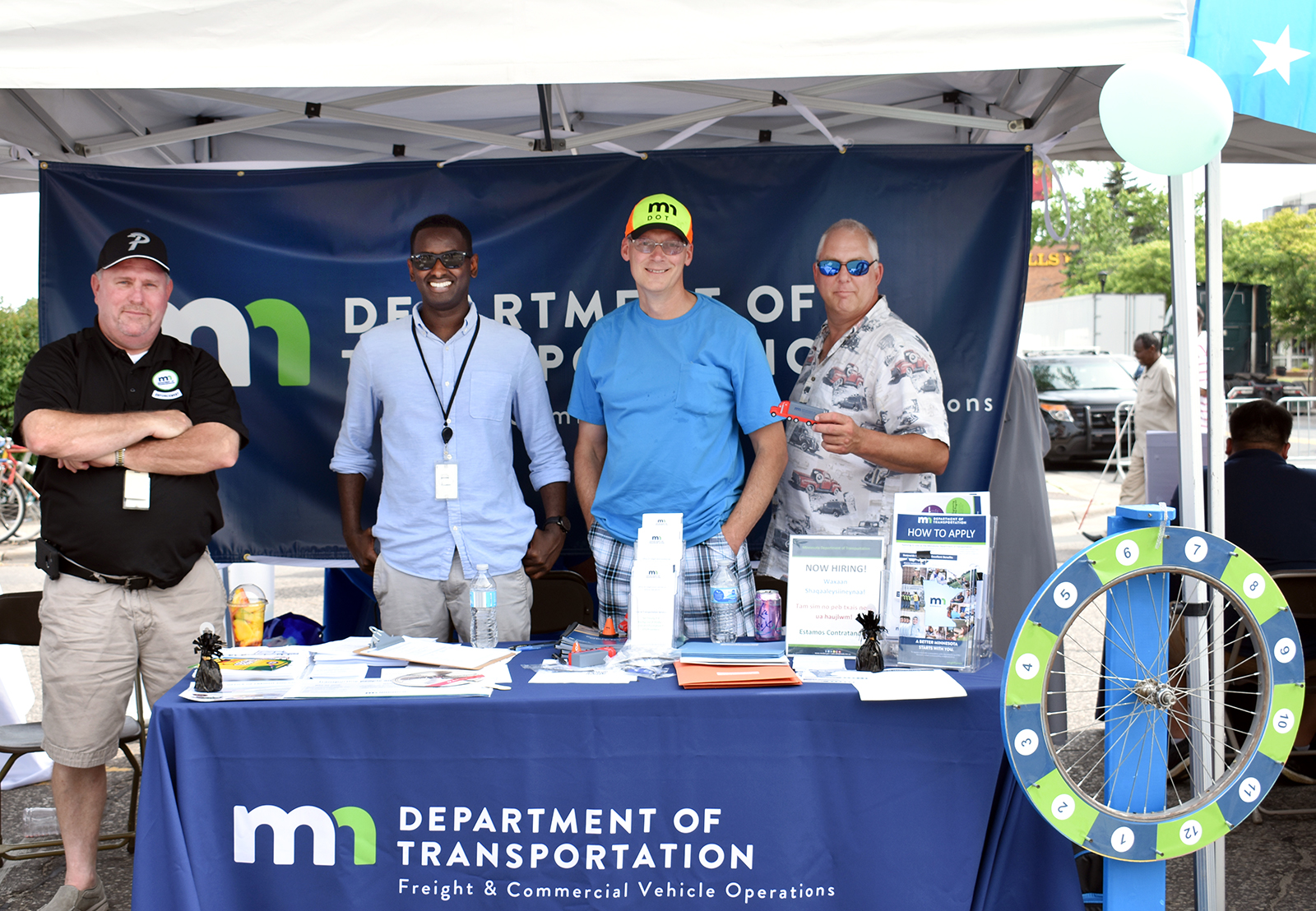 Four men standing in a booth with MnDOT branding on it