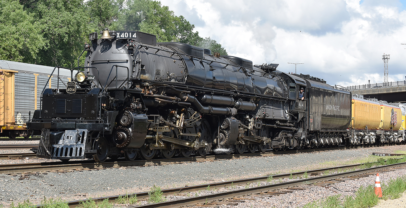 Picture of large steam locomotive towing yellow traincars.