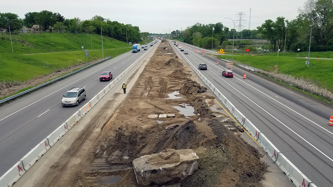 Picture of two road lanes seperated by a large area of dirt.