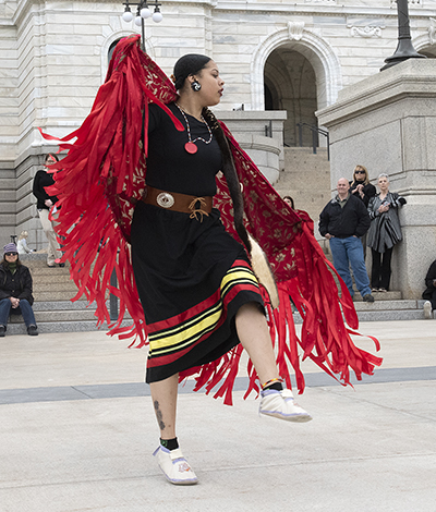 A single dancer performs in front of the state capitol