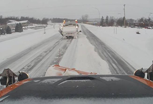 Picture of snowplows on a snowy road.