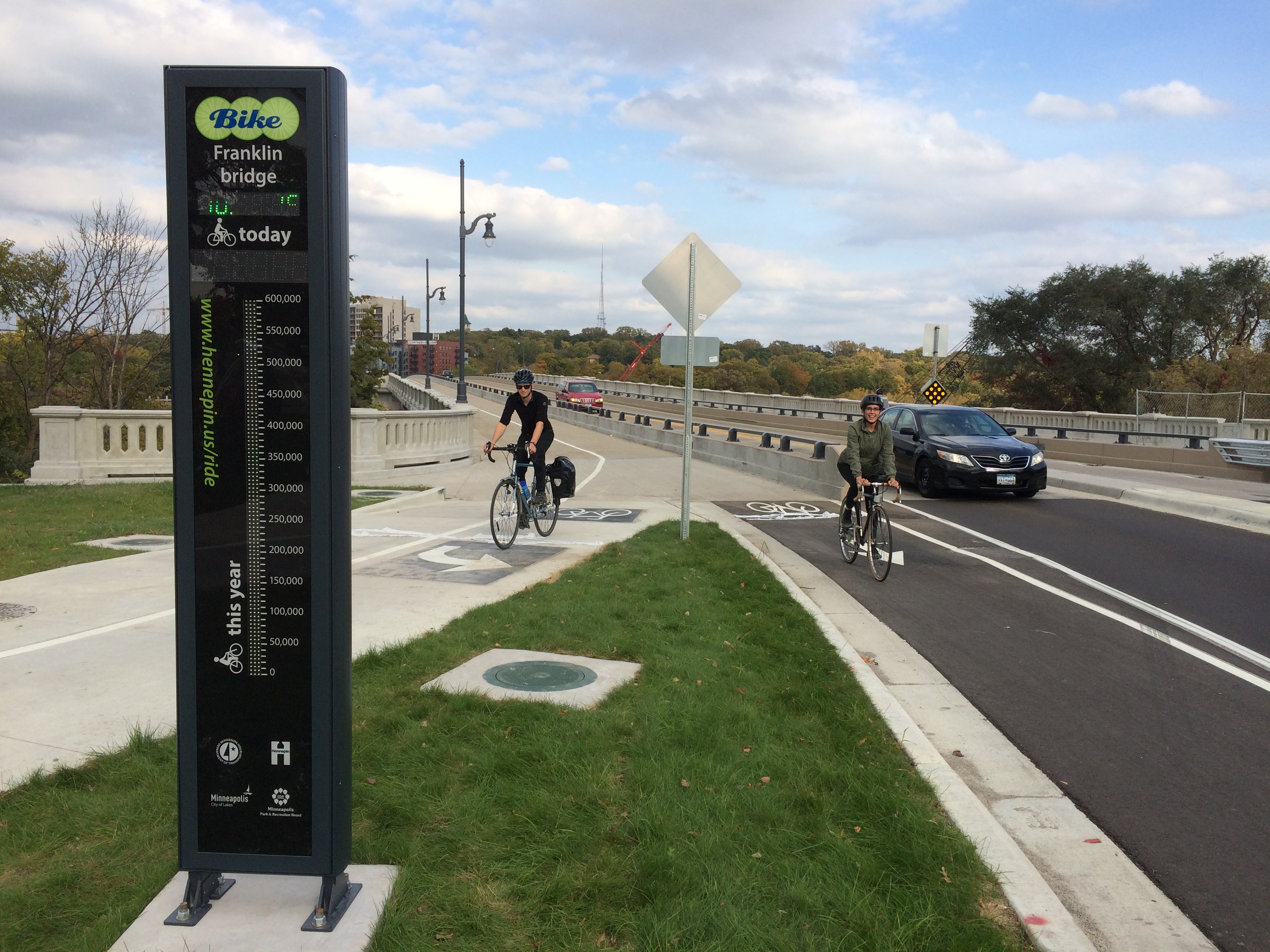 Photo: A bicyclist stopped at an electronic bike and pedestrian counter on the Franklin Avenue bridge. An digital display indicated that 738 people have paassed by the location.