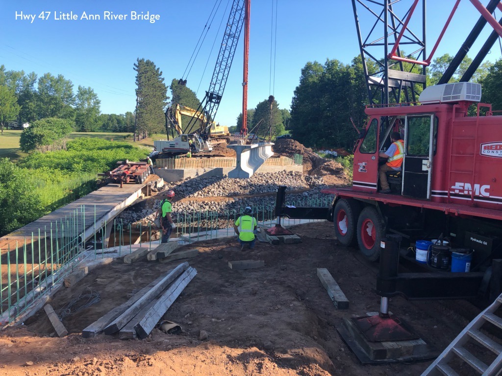 Photo: a crane lifting a beam at a construction site