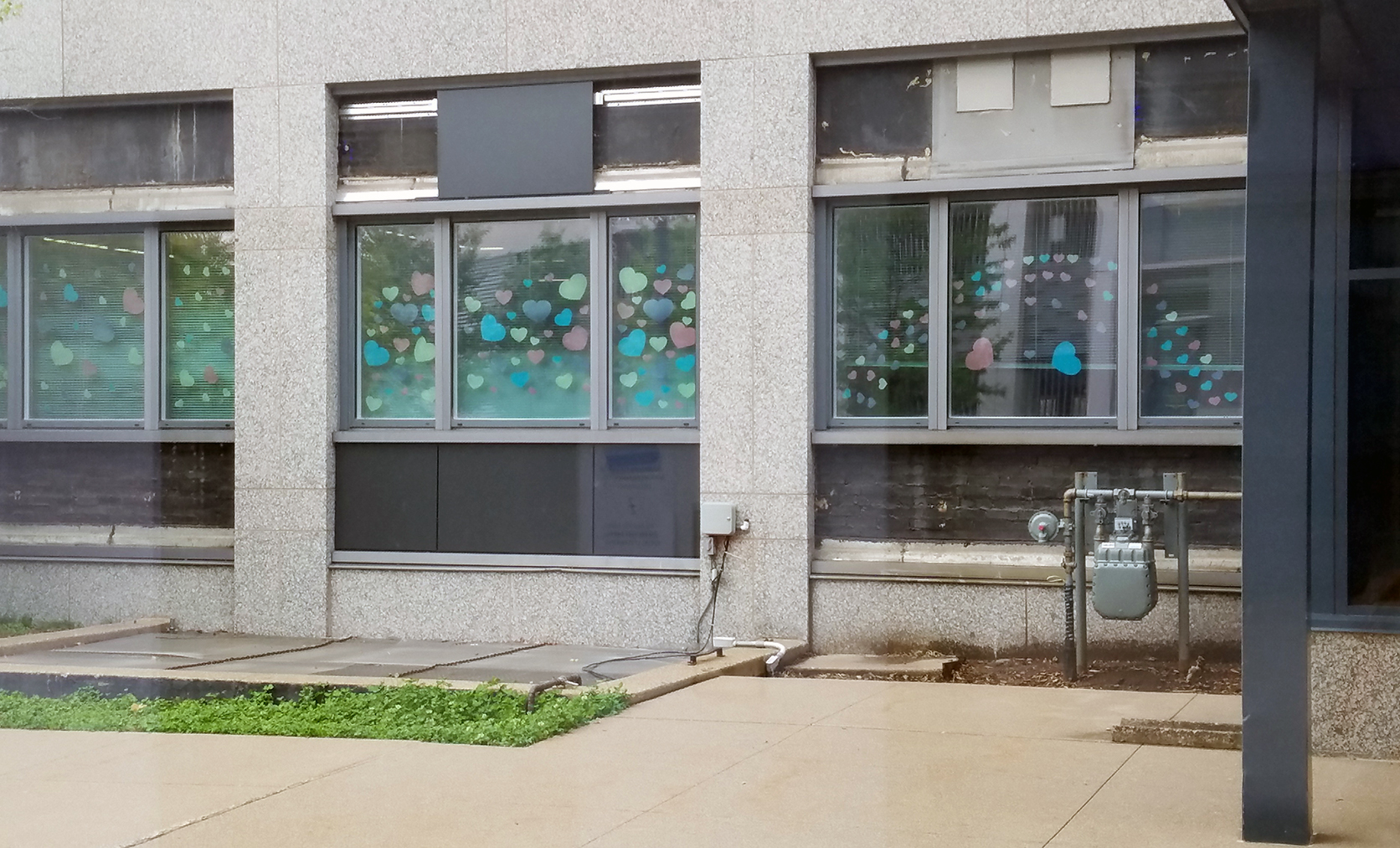 Photo: hearts made out of colored paper, taped up on a window