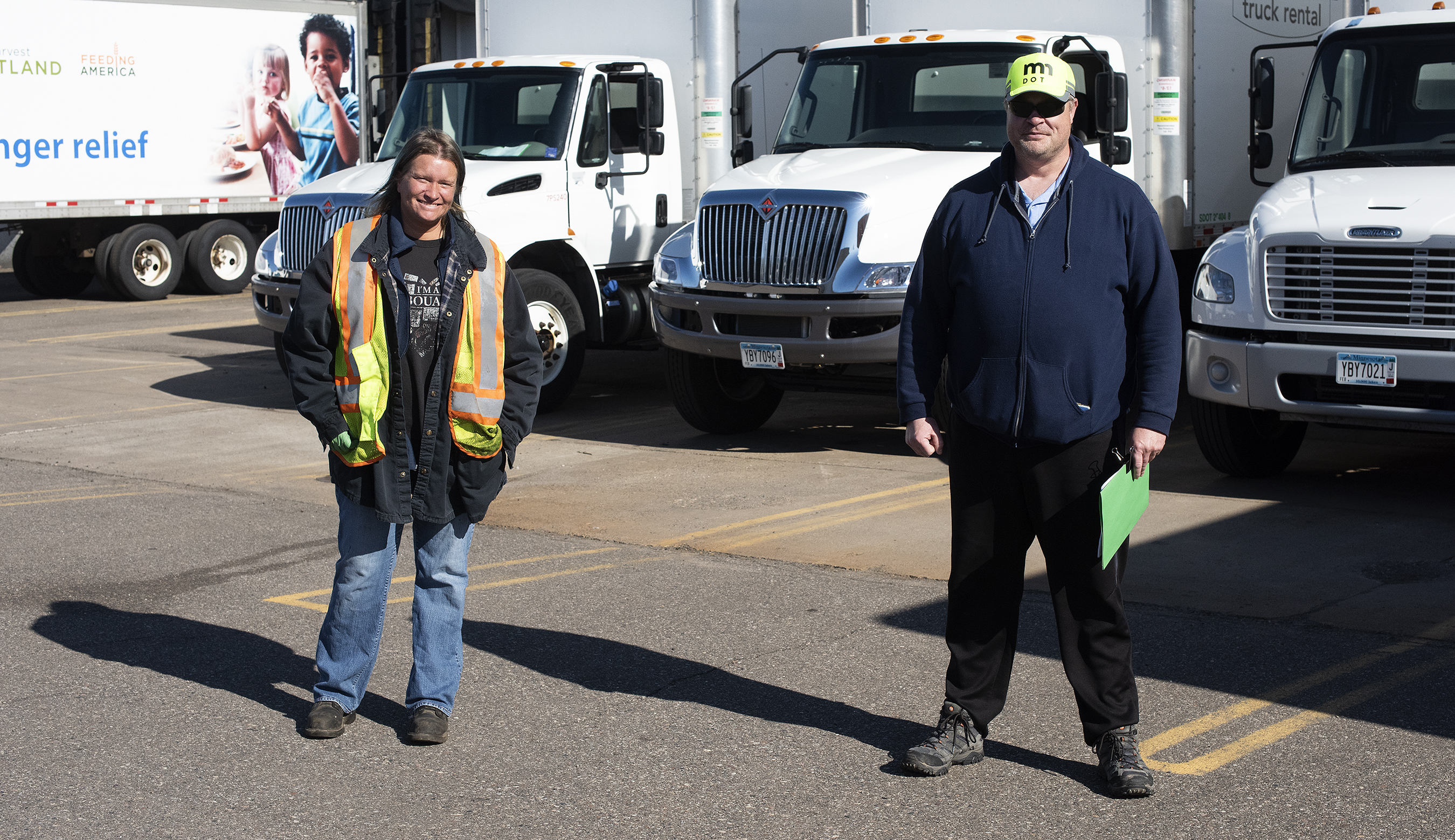 Photo: a man and a woman standing in front of trucks