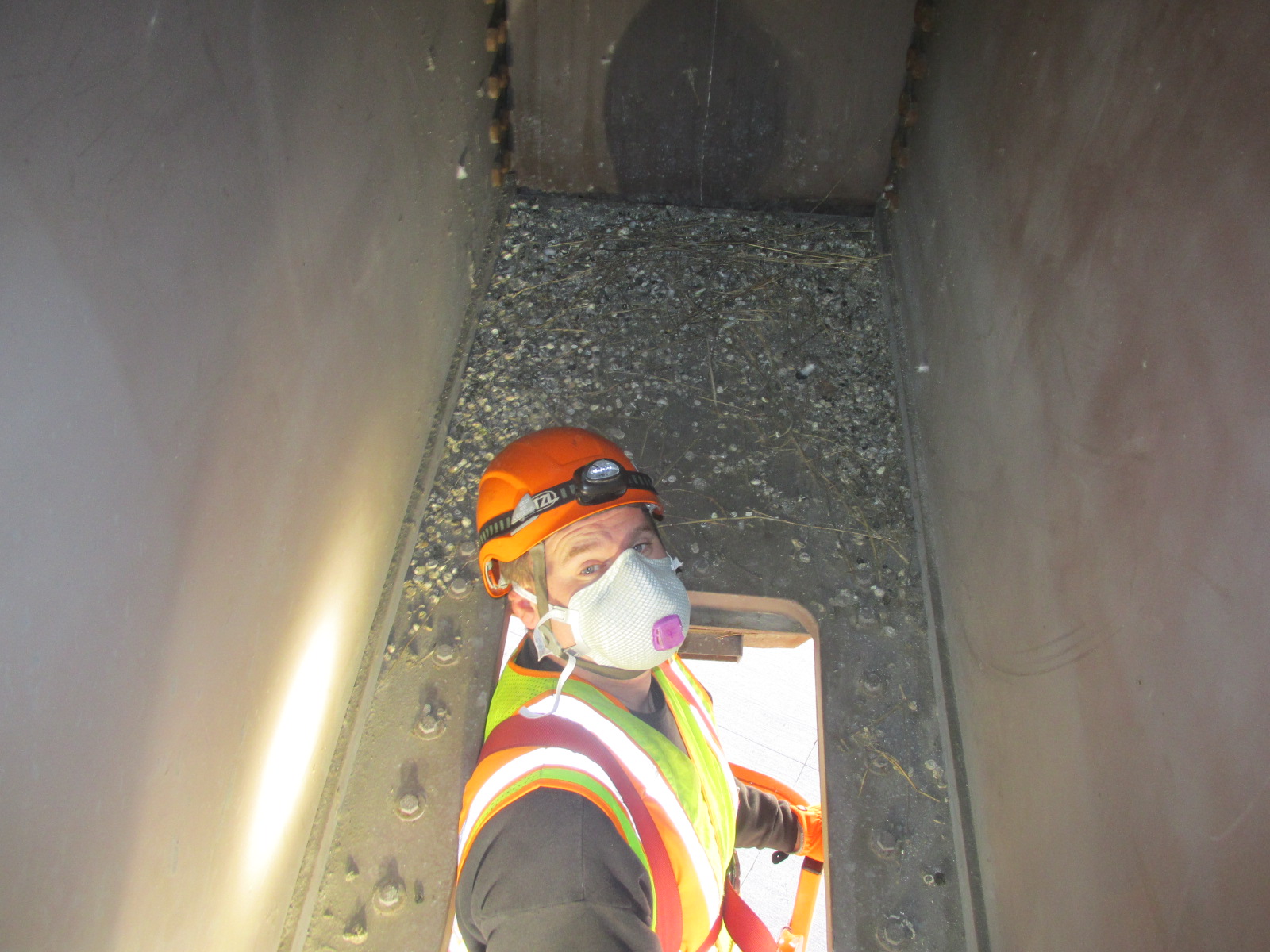 Photo: a worked inside of a bridge. The area is very cramped.