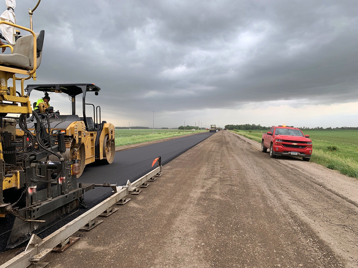 Photo: construction site. One lane is paved, one lane is dirt.