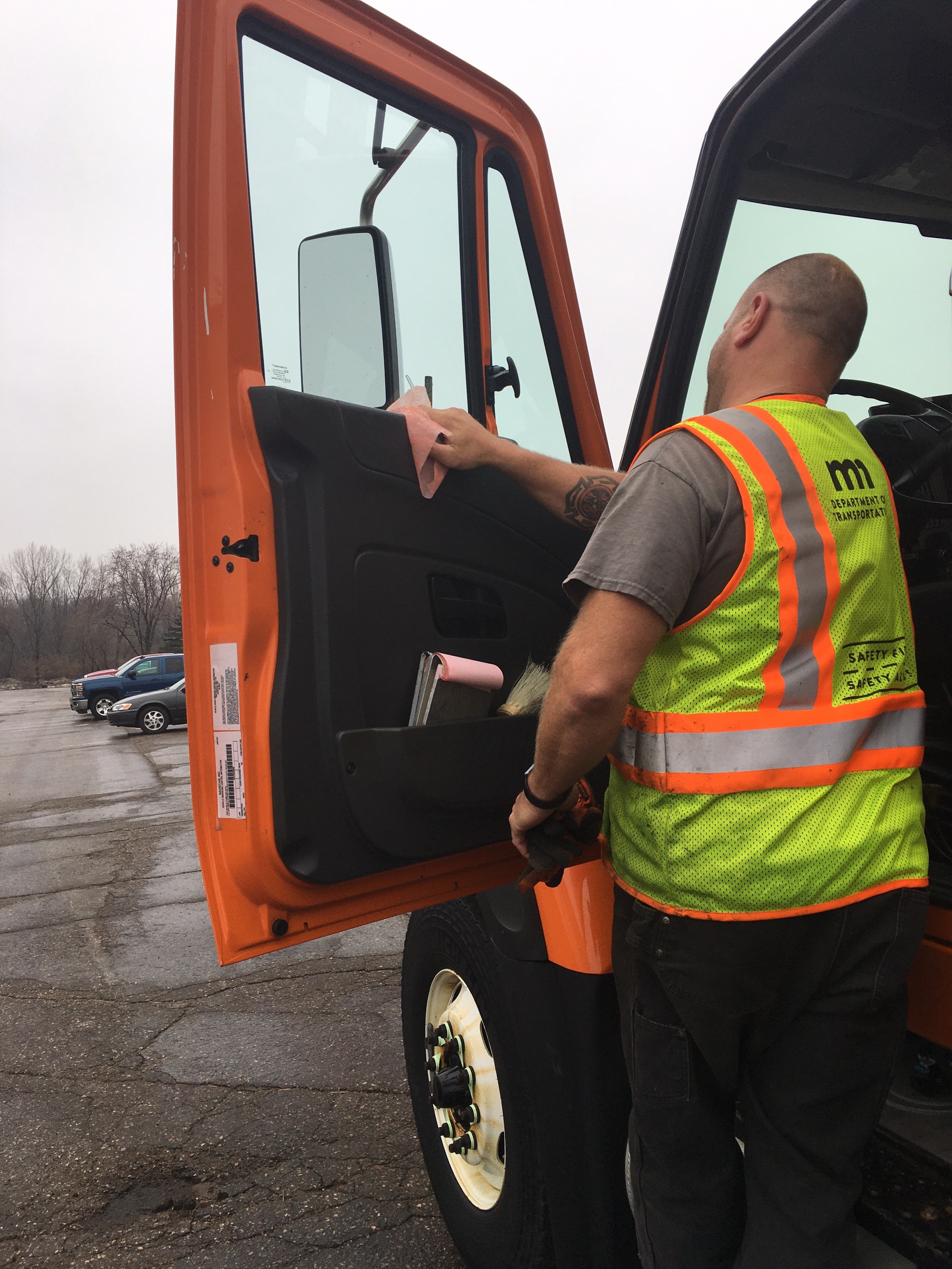 Photo: a driver wiping down the surfaces inside of a truck