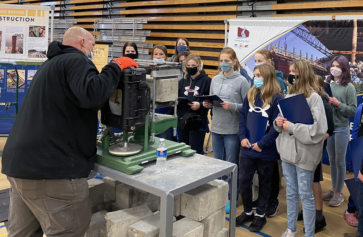 Photo: an employee demonstrating equipment in front of a group of students