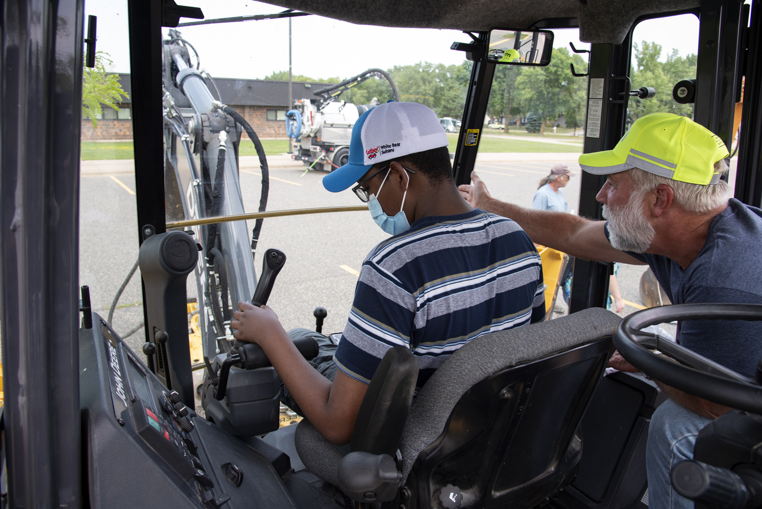 Photo: a student at the controls of a backhoe