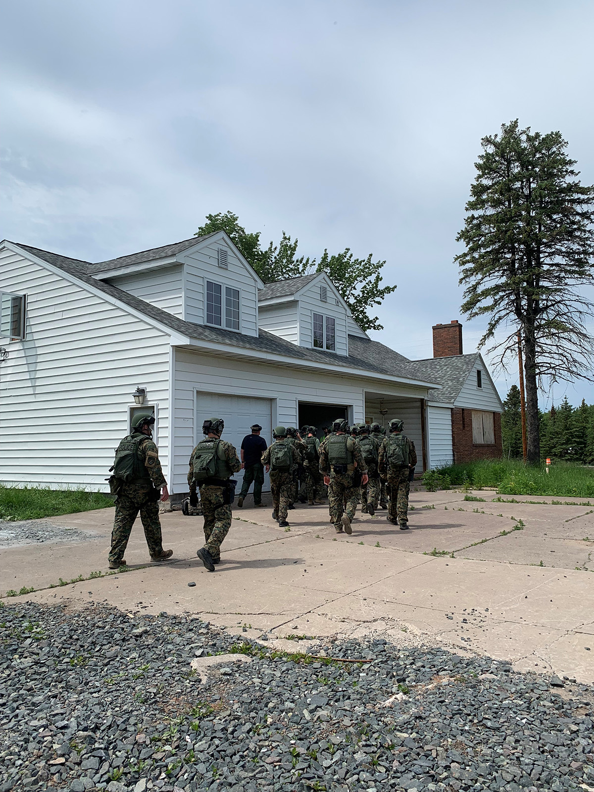 Group of police officers in gear entering a garage