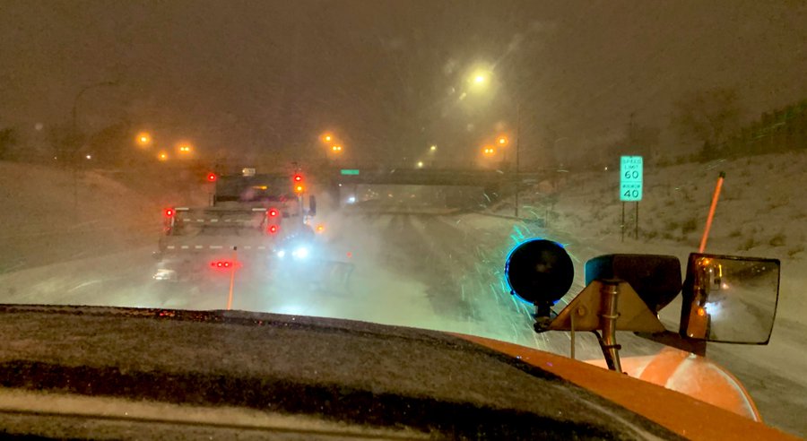 Photo: view through the windshield of a snowplow during a snowstorm