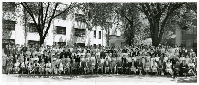 A black and white photograph of about 200 people, linked up in several rows