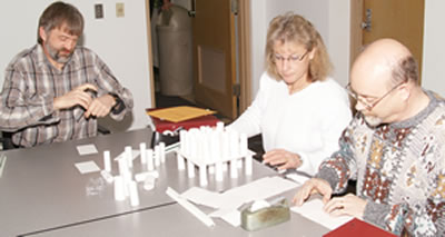 3 people folding paper