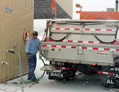 Man fills snowplow with brine