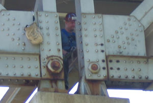 An inspector with a contracting firm observes gusset repair work on the Hwy 43 bridge in Winona. Photo by Craig Falkum