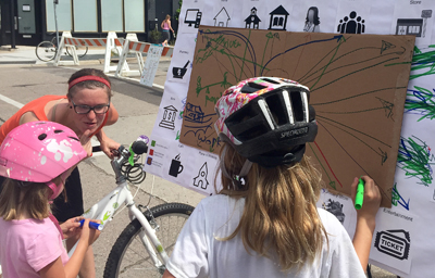 Photo of Greta Alquist talking young bicyclists.