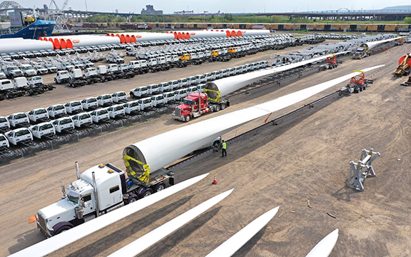 Picture of large wind turbine blade being towed by a semi.