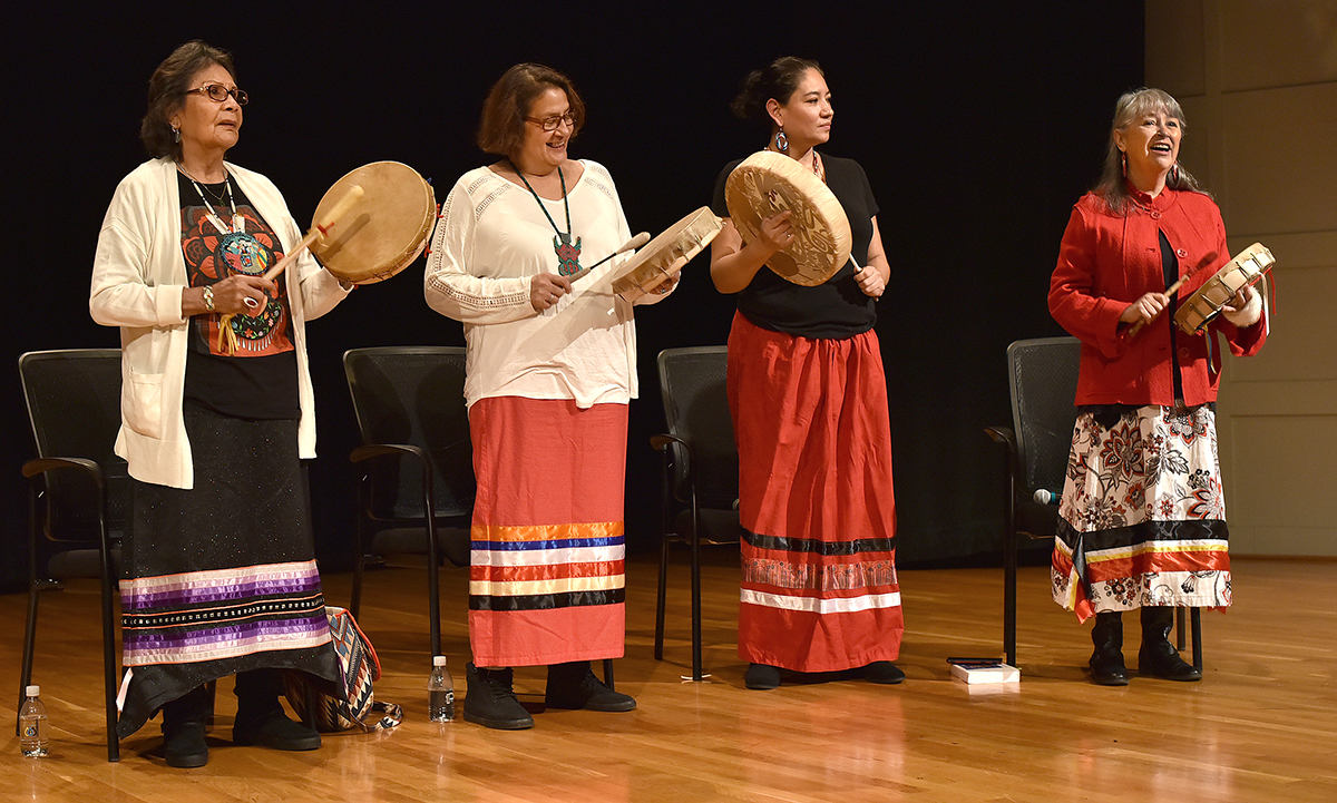 Photo: four women drumming on a stage
