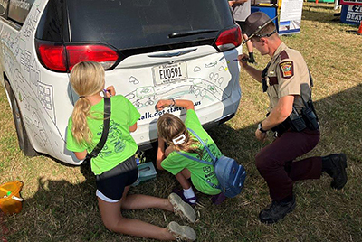 Photo: State Trooper and kids drawing on GoMobile.